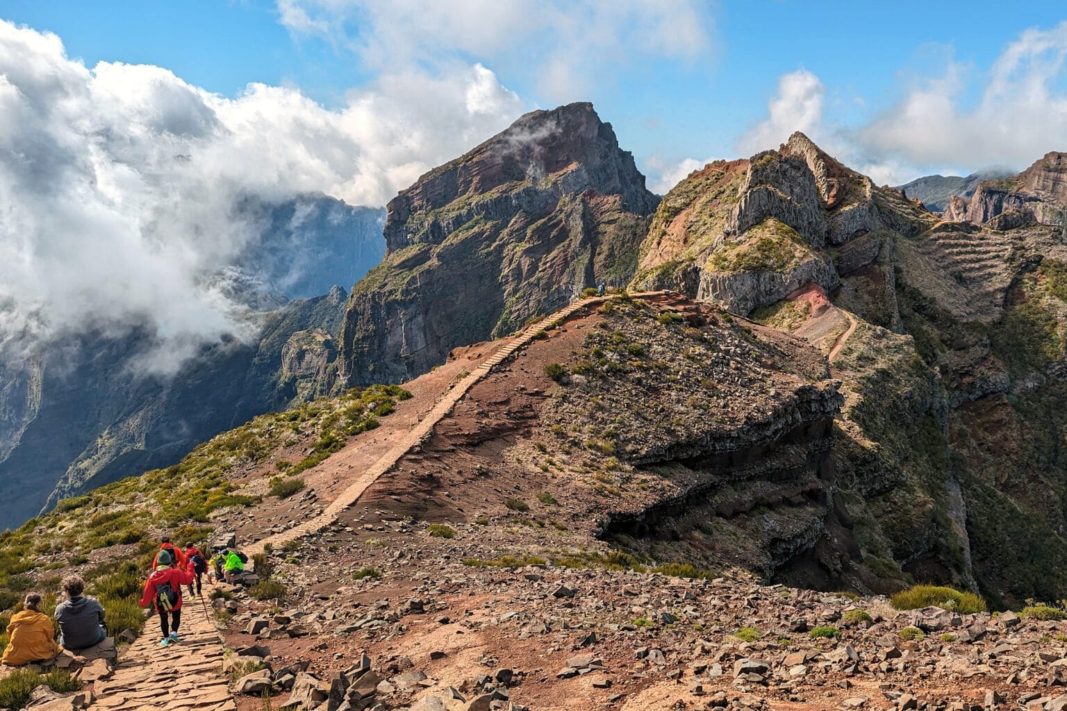 Pico do Arieiro path on a clear day with strong colors, sharp contrasts, rocky peaks and bright blue sky