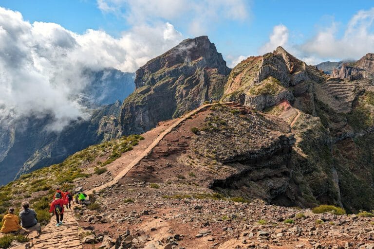 Pico do Arieiro path on a clear day with strong colors, sharp contrasts, rocky peaks and bright blue sky